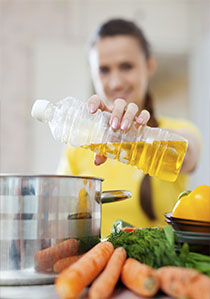 mujer echando aceite en una cacerola